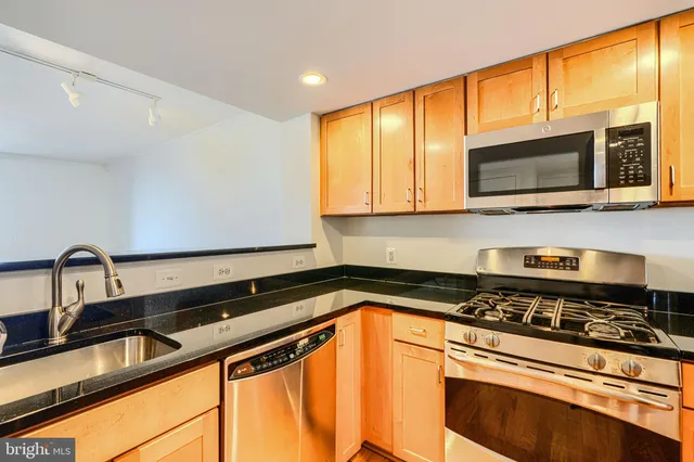a kitchen with stainless steel appliances a stove a sink microwave and cabinets