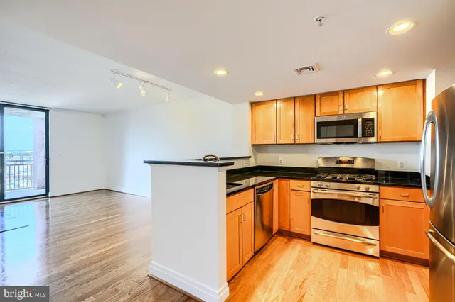 a kitchen with stainless steel appliances granite countertop a stove a sink and a microwave