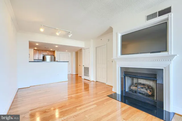 a view of a livingroom with wooden floor and a fireplace
