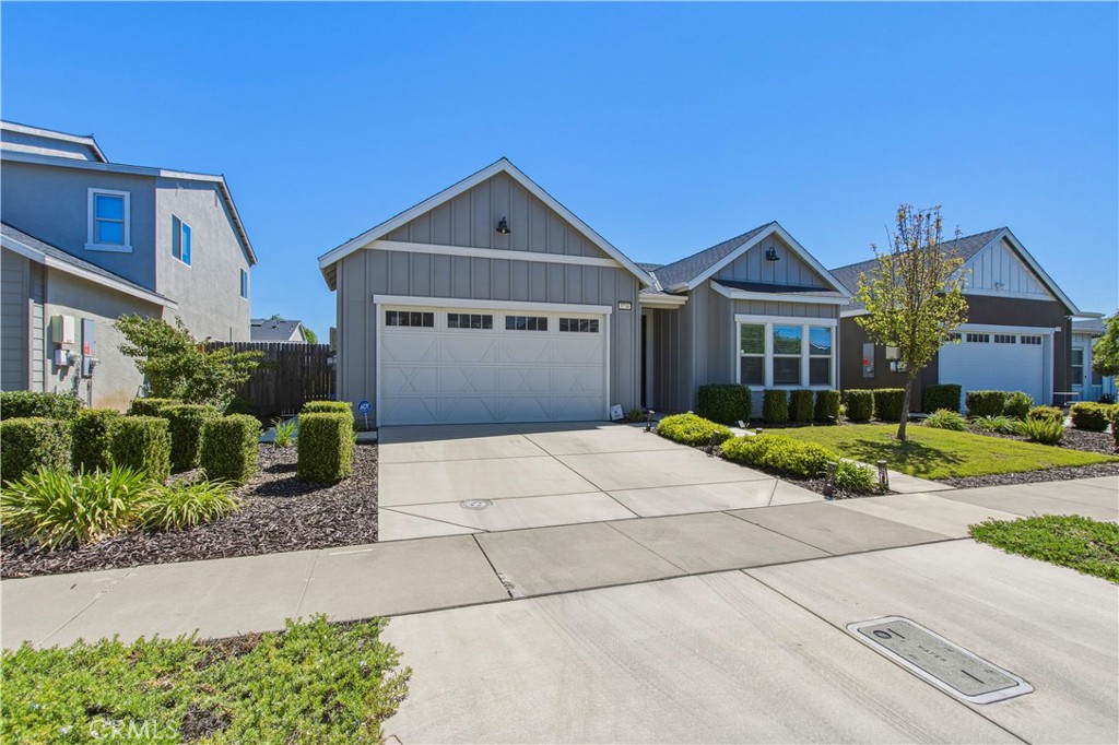 a front view of a house with a yard and potted plants