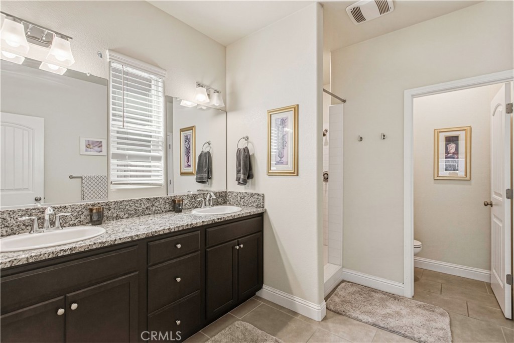 3716 Magellan Drive Merced, CA 95340 - Photo 18 of 27 a bathroom with a granite countertop sink a mirror and a