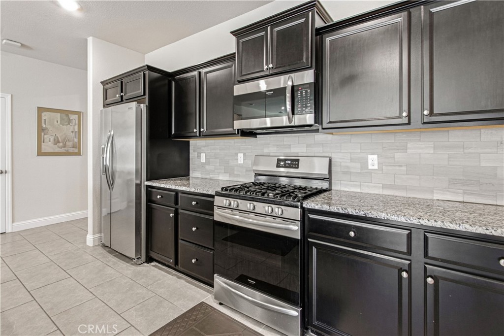 3716 Magellan Drive Merced, CA 95340 - Photo 6 of 27 a kitchen with stainless steel appliances granite countertop a stove and a microwave