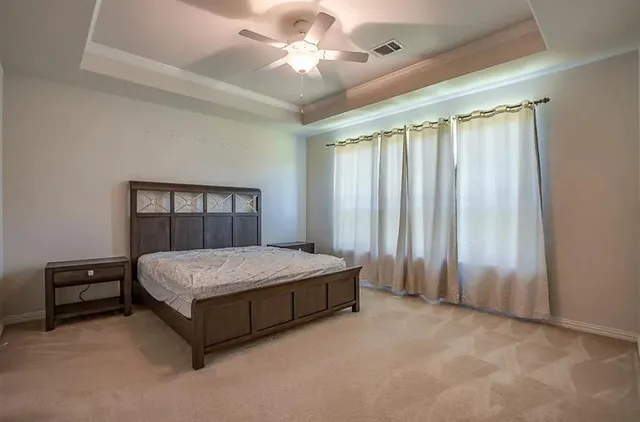 a spacious bedroom with a bed and a chandelier