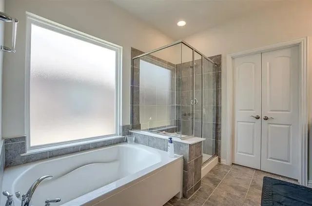 a bathroom with a tub a sink and a shower