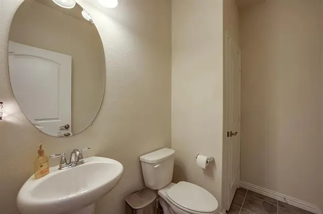 a bathroom with a toilet a sink and mirror
