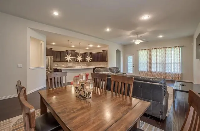 a large dining space with furniture a kitchen and chandelier