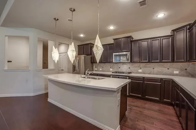 a kitchen with stainless steel appliances granite countertop a sink stove and microwave