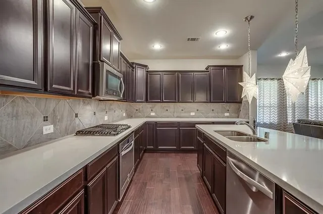 a kitchen that has a sink a stove and cabinets