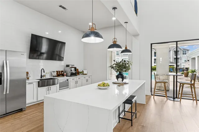 a kitchen with stainless steel appliances a kitchen island a stove a table and chairs in it