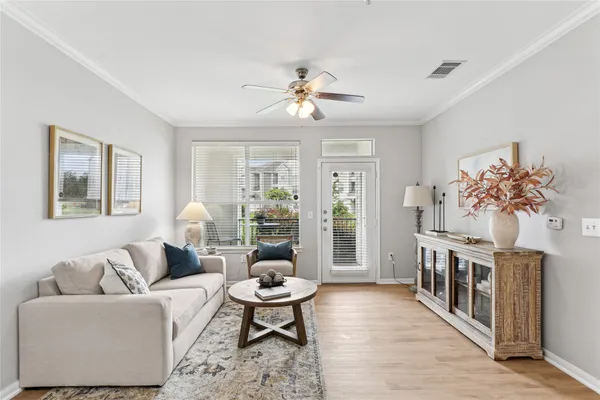 a living room with furniture a chandelier and a window