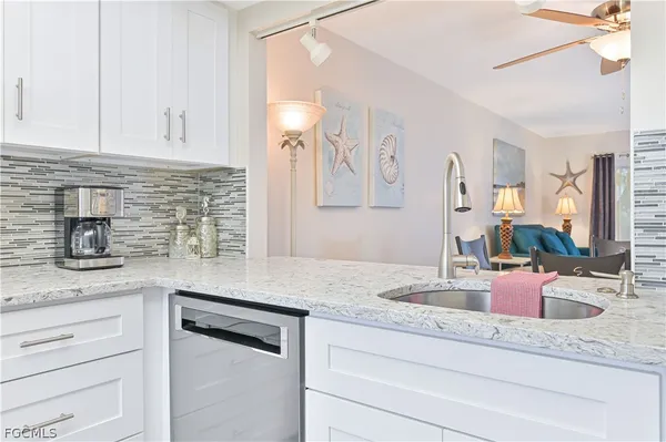a kitchen with granite countertop a sink and cabinets