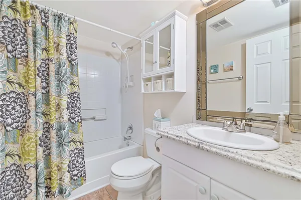 a bathroom with a granite countertop sink toilet a mirror a shower and a toilet