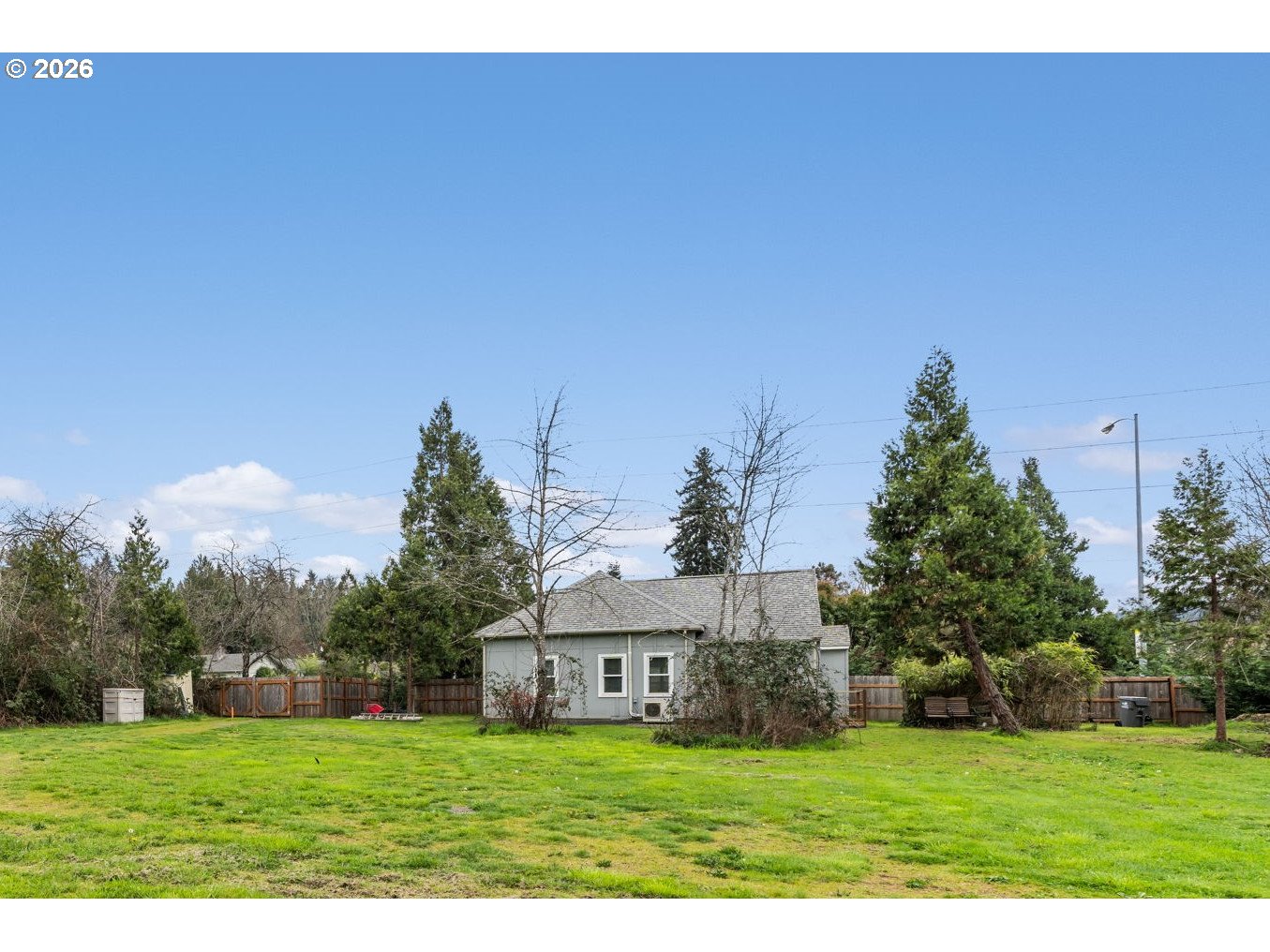 3315 West 18th Avenue Eugene, OR 97402 - Photo 17 of 26 a view of a white house with a big yard and large trees