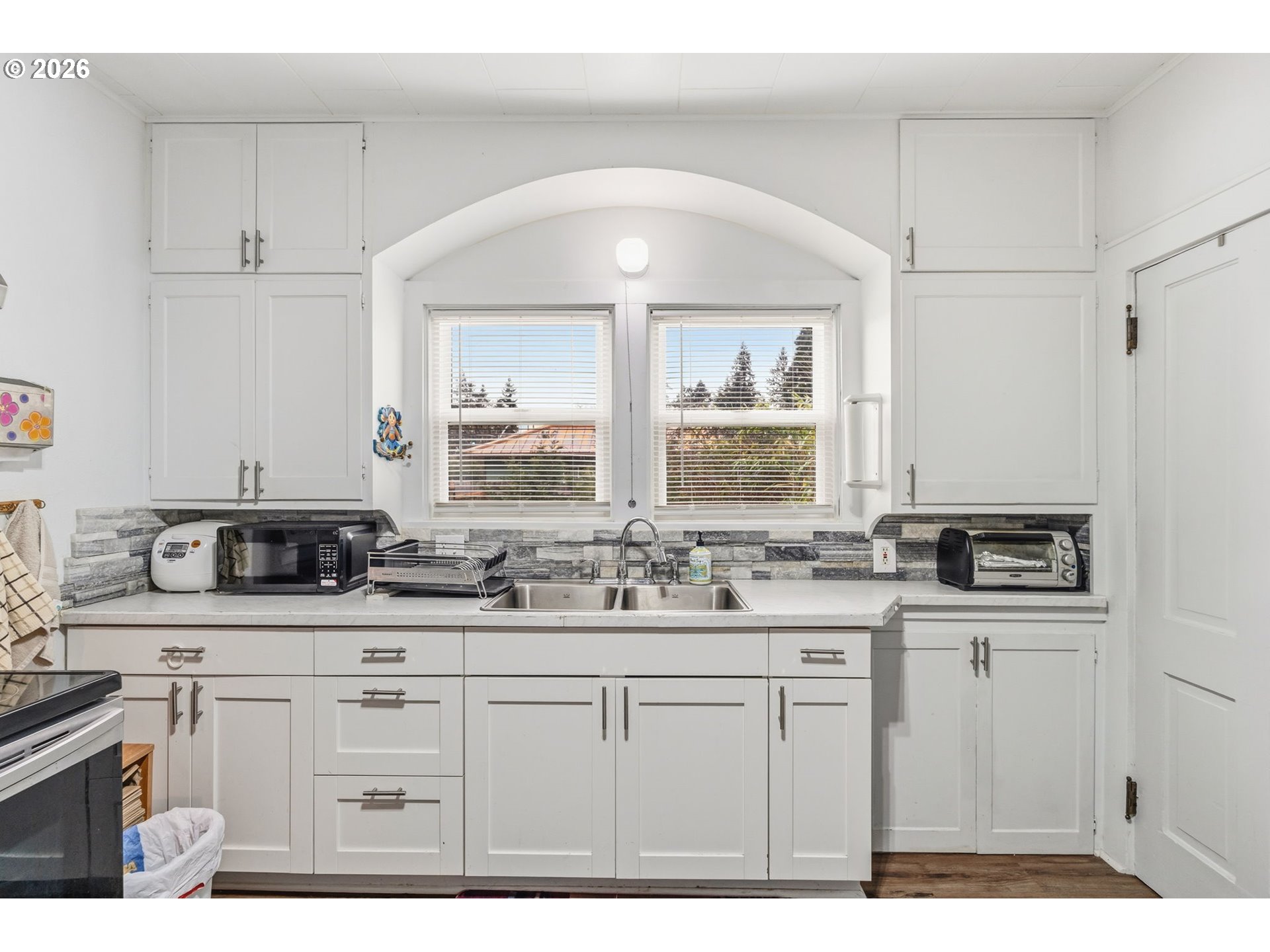 3315 West 18th Avenue Eugene, OR 97402 - Photo 6 of 26 a kitchen with a sink a window and cabinets