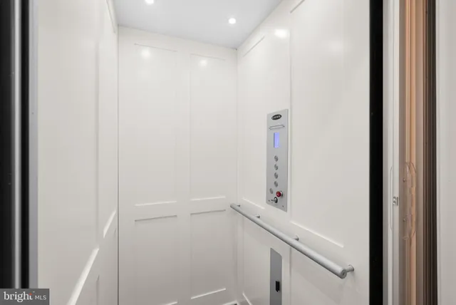 a large kitchen with kitchen island a stove a refrigerator a sink dishwasher and white cabinets with wooden floor