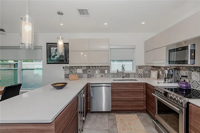a kitchen with a sink and lots of potted plants