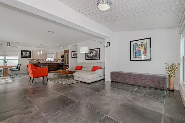 a view of yellow house with a yard and palm trees