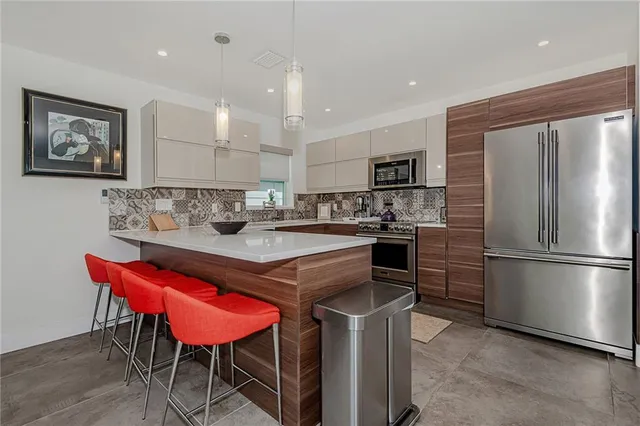 a kitchen with a refrigerator a stove a sink and a chairs