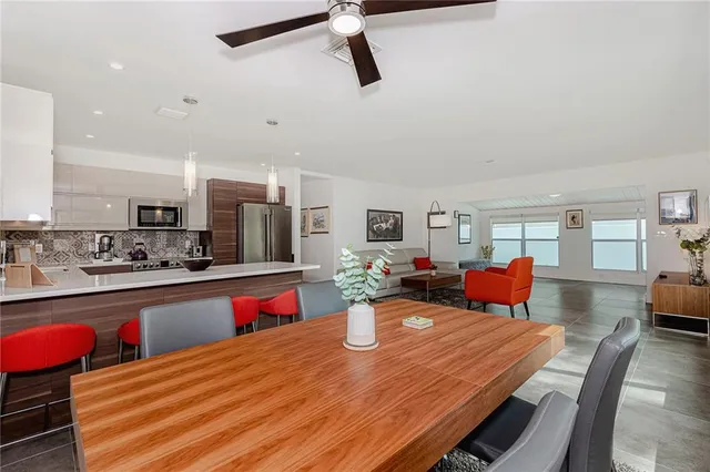 a open kitchen with stainless steel appliances stove refrigerator dining table and chairs