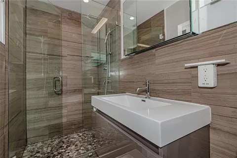 a bathroom with a sink a mirror and shower