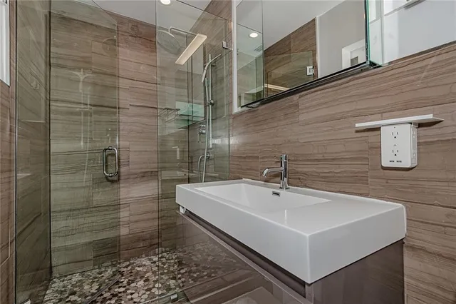 a bathroom with a sink a mirror and shower
