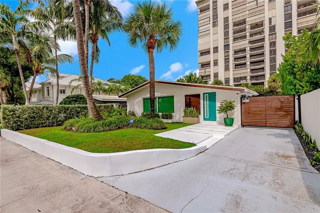 a front view of a house with a yard and potted plants