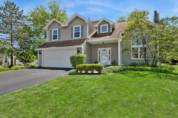 a front view of a house with a garden and yard
