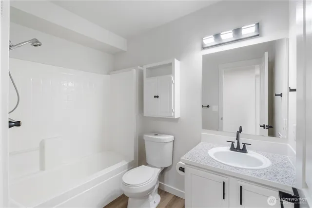 a bathroom with a sink toilet vanity and shower