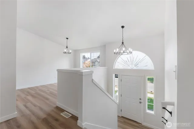 a view of a hallway with windows and chandelier