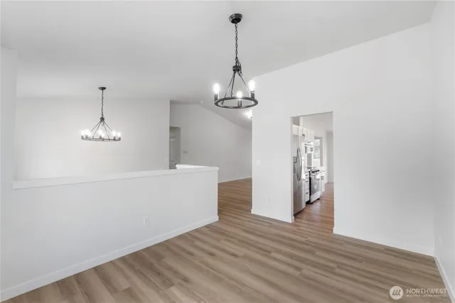 a view of a room with wooden floor chandelier and a window