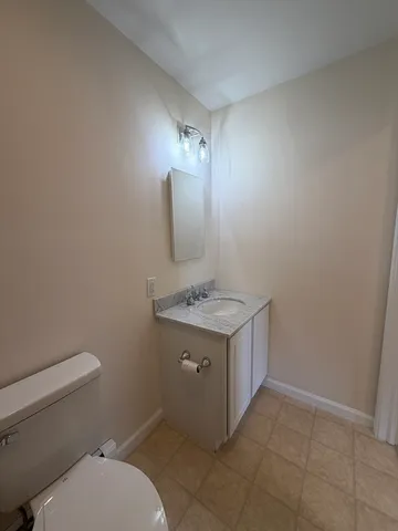 a bathroom with a granite countertop toilet sink and mirror