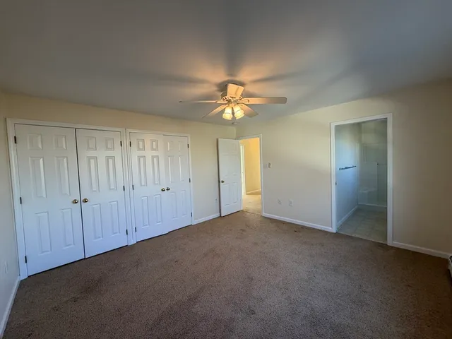 an empty room with a ceiling fan and a window