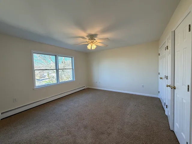 an empty room with windows and fan