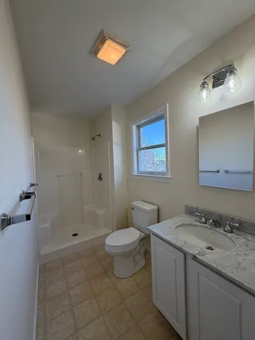 a bathroom with a granite countertop sink toilet and shower