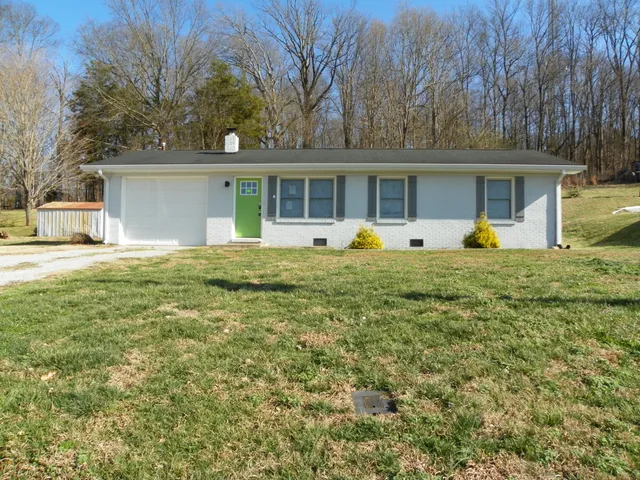 a front view of a house with a yard and trees