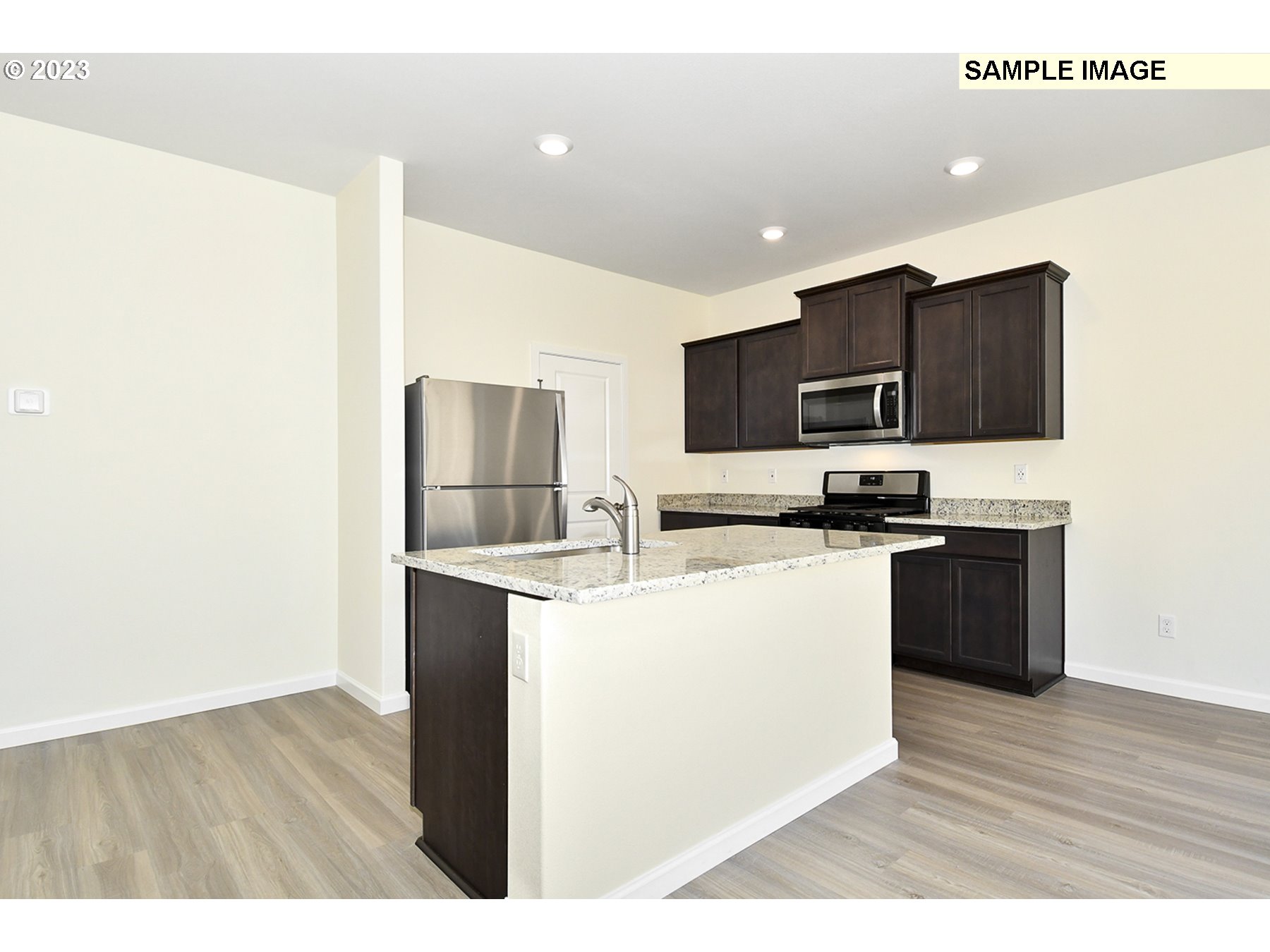 3956 Southwest Knapp Drive Gresham, OR 97080 - Photo 5 of 14 a kitchen with stainless steel appliances kitchen island a sink dishwasher a refrigerator and a stove with wooden floor