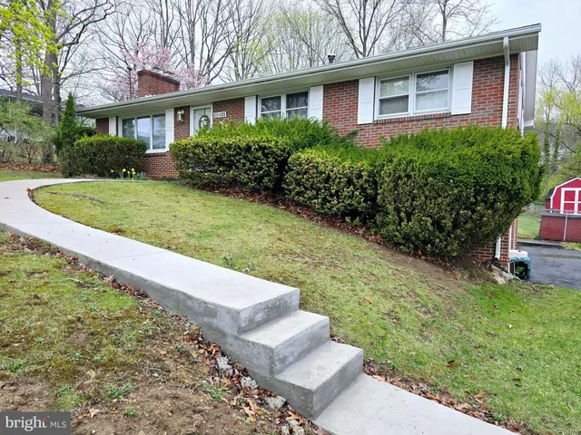 a view of a house with a yard and potted plants