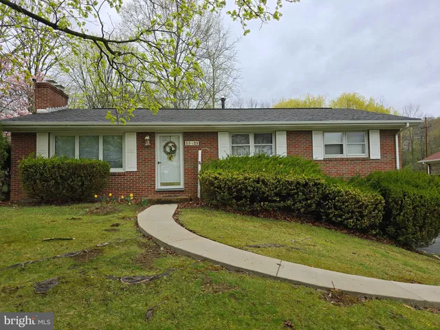 a front view of a house with a yard and trees