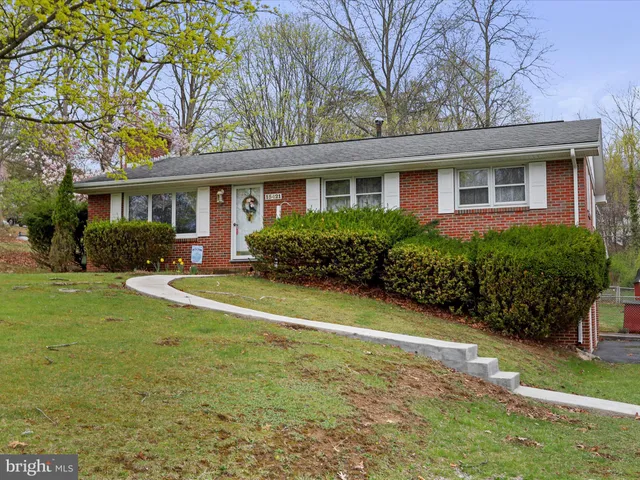 a view of a house with potted plants and a table and chairs