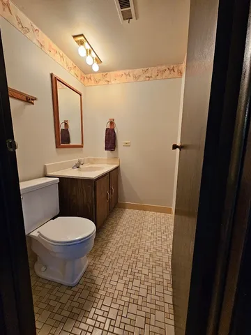 a bathroom with a toilet a sink and mirror