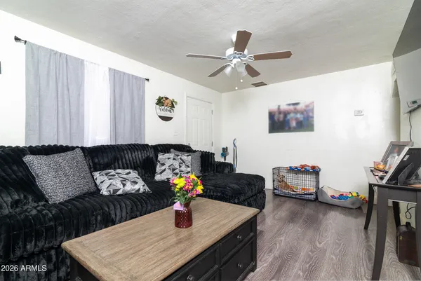 a living room with furniture a flat screen tv and wooden floor