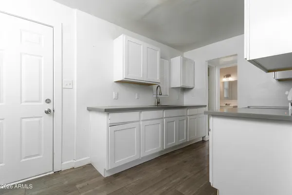 a kitchen with wooden floors and white appliances