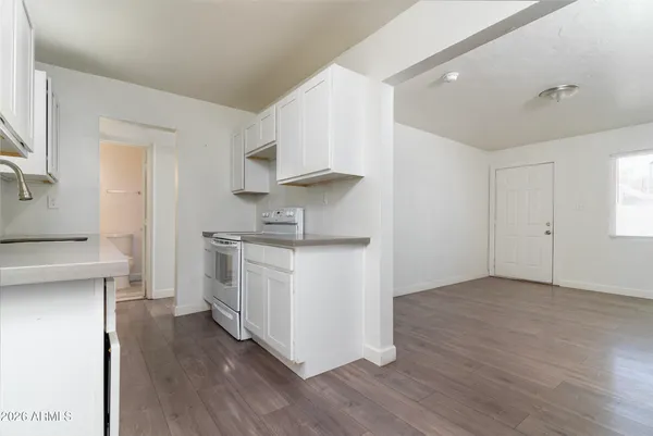 a kitchen with cabinets appliances and a wooden floor