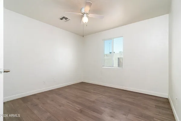 a view of an empty room with wooden floor