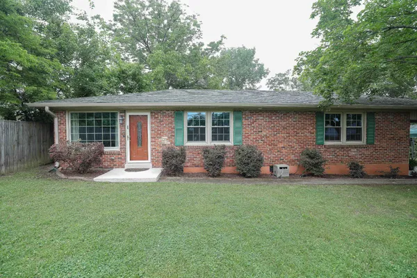 a view of a house with a yard and porch