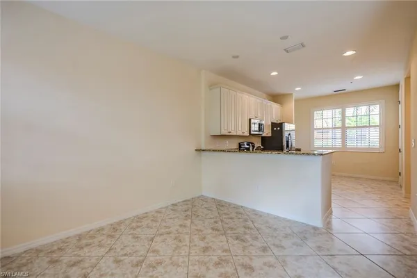 a kitchen with granite countertop a stove a sink and a microwave