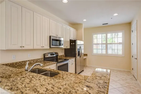 a kitchen with stainless steel appliances granite countertop a stove a sink and a refrigerator