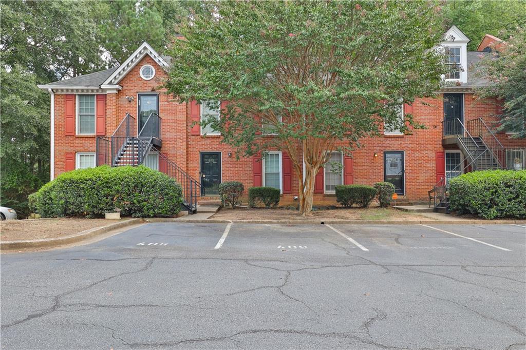 1166 Booth Road Southwest, Unit 406 Marietta, GA 30008 - Photo 1 of 1 front view of a brick house with a yard and plants