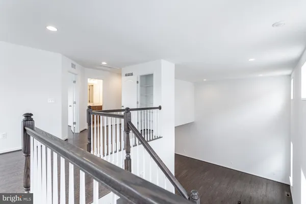 a view of a hallway with wooden floor and stairs