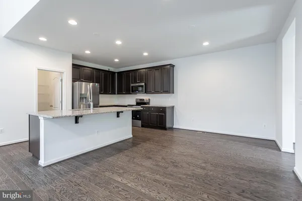 a kitchen with granite countertop a refrigerator and a sink